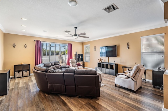 living room with ceiling fan, wood-type flooring, a textured ceiling, and ornamental molding