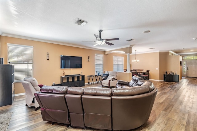 living room with crown molding, plenty of natural light, and wood-type flooring