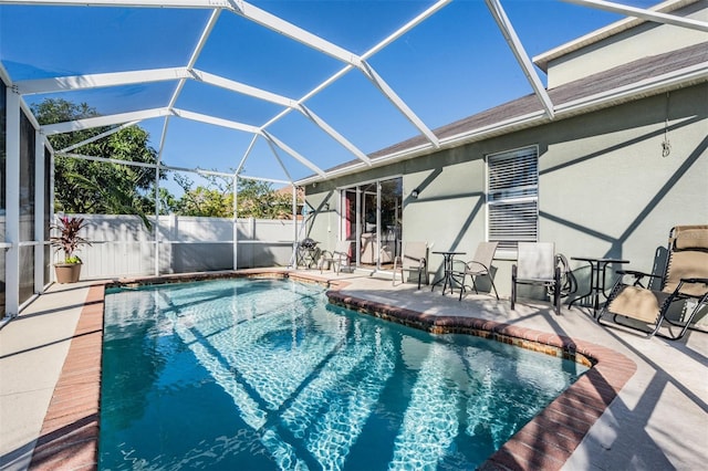 view of pool with glass enclosure and a patio