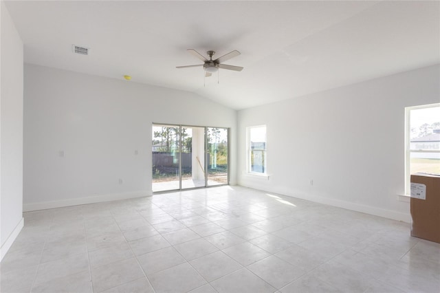 spare room featuring ceiling fan, light tile patterned floors, a healthy amount of sunlight, and vaulted ceiling