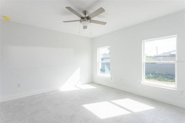 tiled spare room with ceiling fan