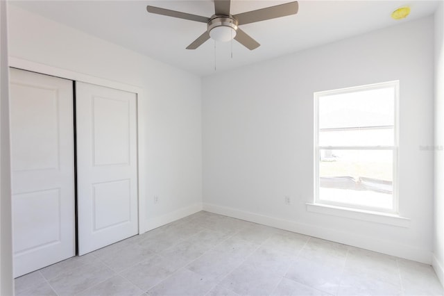 unfurnished bedroom with ceiling fan, light tile patterned floors, and a closet