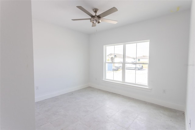 empty room with ceiling fan and light tile patterned flooring