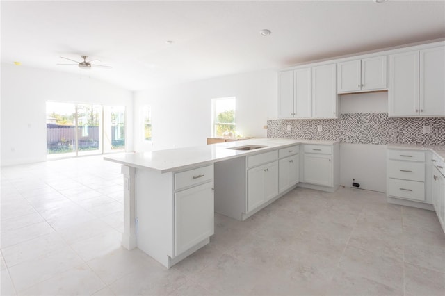 kitchen with tasteful backsplash, white cabinetry, ceiling fan, and plenty of natural light