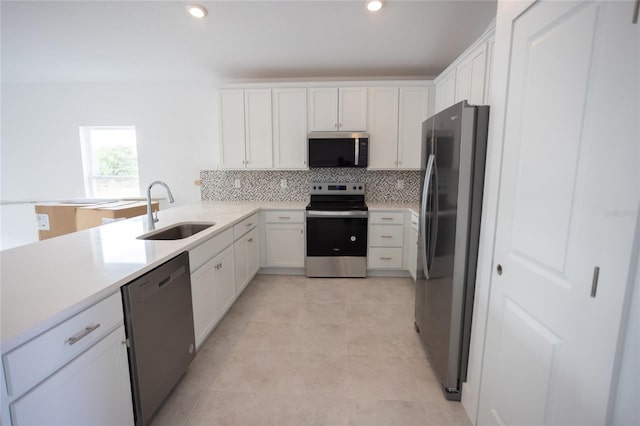 kitchen featuring appliances with stainless steel finishes, sink, white cabinets, and backsplash