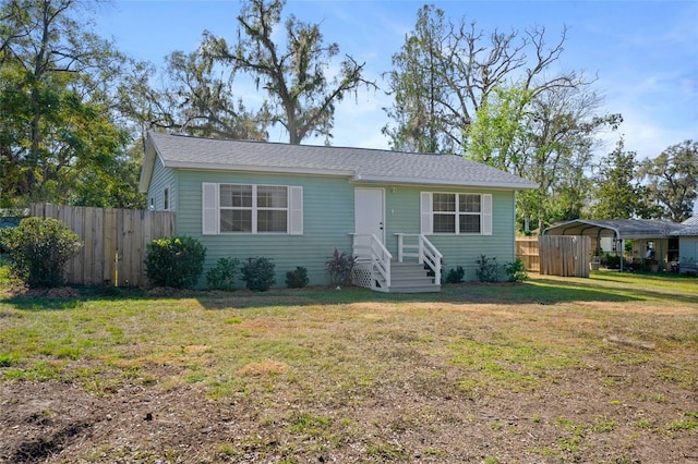 view of front of property featuring a front lawn and a carport