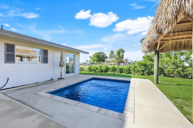 view of pool featuring a lawn and a patio area