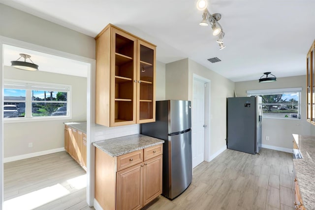 kitchen featuring plenty of natural light, stainless steel fridge, and light hardwood / wood-style floors