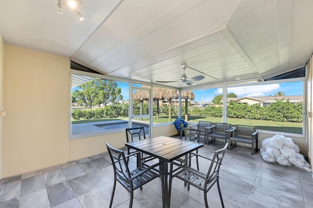 sunroom / solarium with ceiling fan and vaulted ceiling