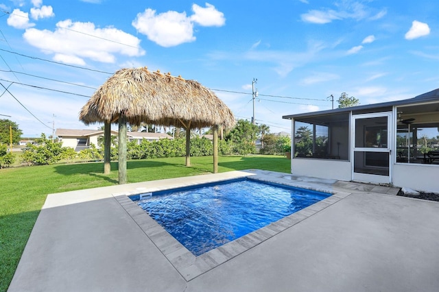 view of pool with a lawn, a sunroom, and a patio