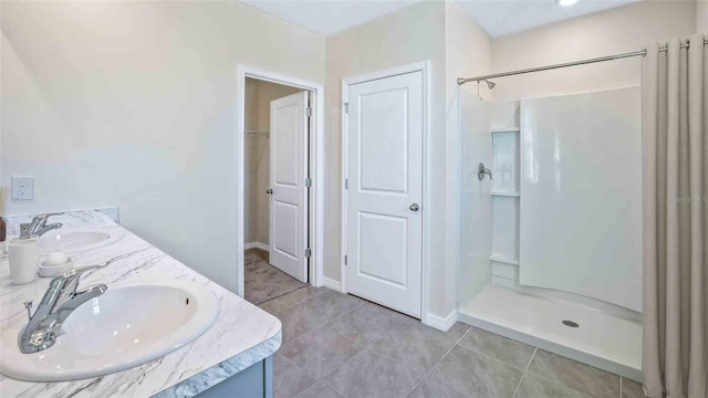 bathroom with a shower, vanity, and tile patterned floors