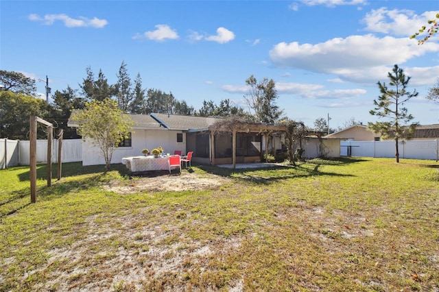 rear view of property with a lawn and a sunroom