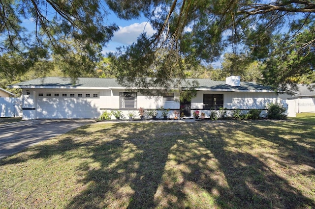 single story home featuring a garage and a front lawn