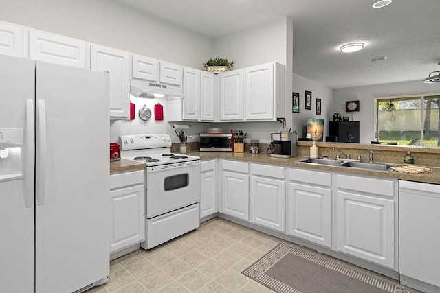 kitchen with white cabinets, a textured ceiling, white appliances, and sink