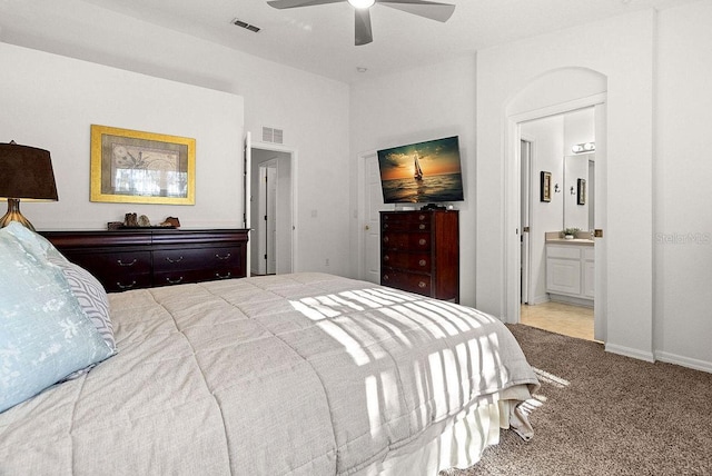 bedroom featuring light carpet, connected bathroom, and ceiling fan