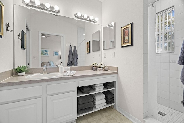 bathroom featuring ceiling fan, vanity, and tiled shower