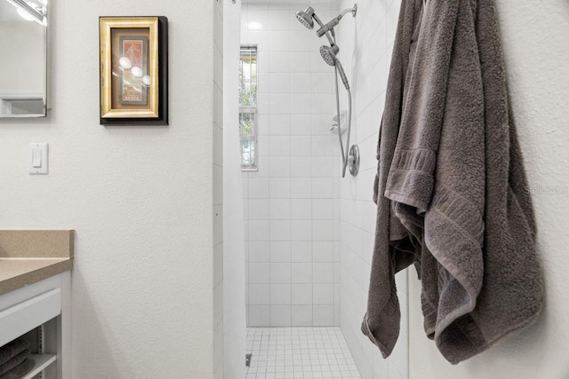 bathroom featuring a tile shower and vanity