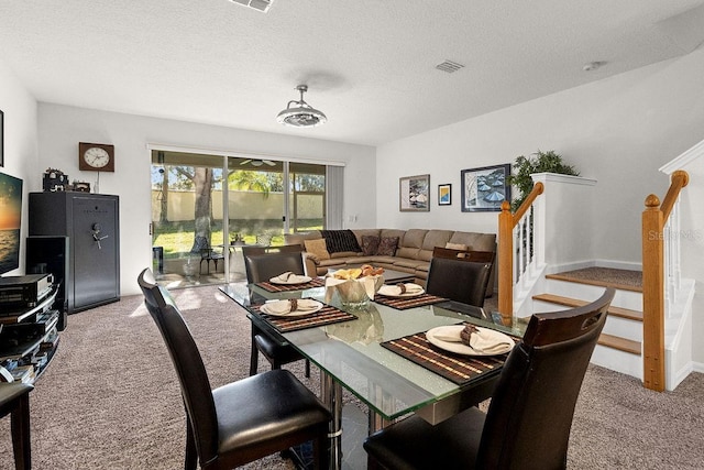 dining room featuring light carpet and a textured ceiling