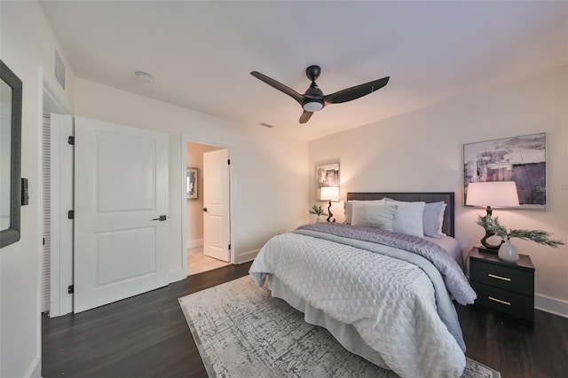 bedroom featuring dark hardwood / wood-style floors, ceiling fan, and ensuite bath