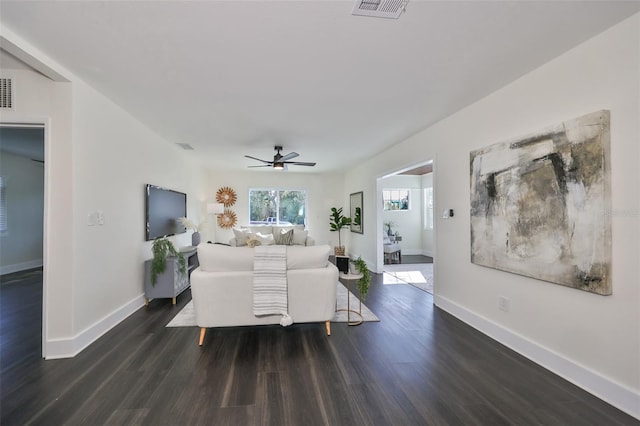 living room with dark hardwood / wood-style flooring and ceiling fan