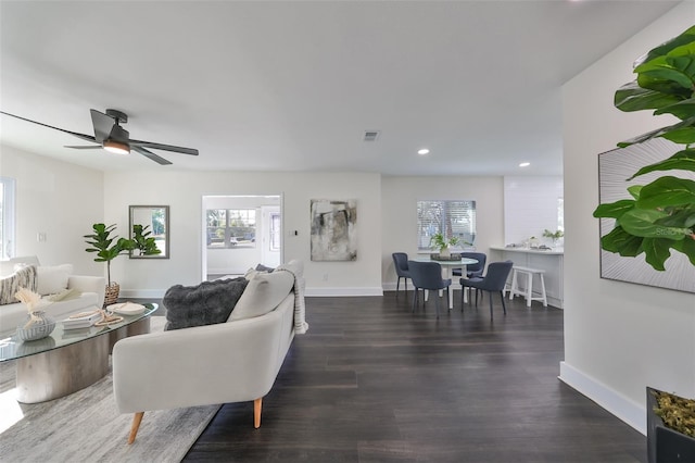 living room with ceiling fan, plenty of natural light, and dark hardwood / wood-style floors