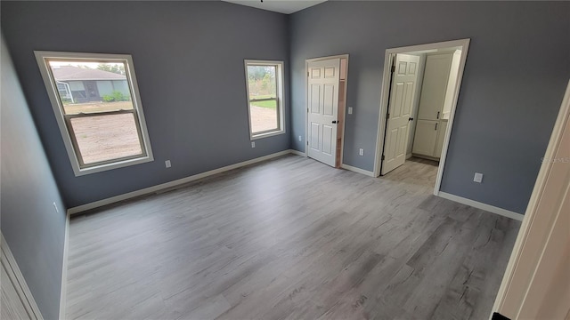 spare room with plenty of natural light and light hardwood / wood-style floors