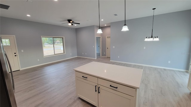 kitchen with ceiling fan, light hardwood / wood-style flooring, a center island, white cabinetry, and hanging light fixtures