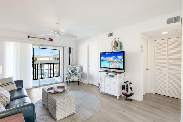 living room with ceiling fan and light wood-type flooring