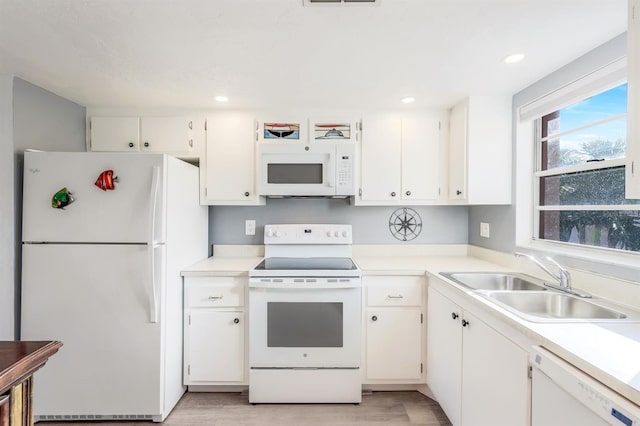 kitchen featuring light wood-type flooring, white appliances, white cabinetry, and sink