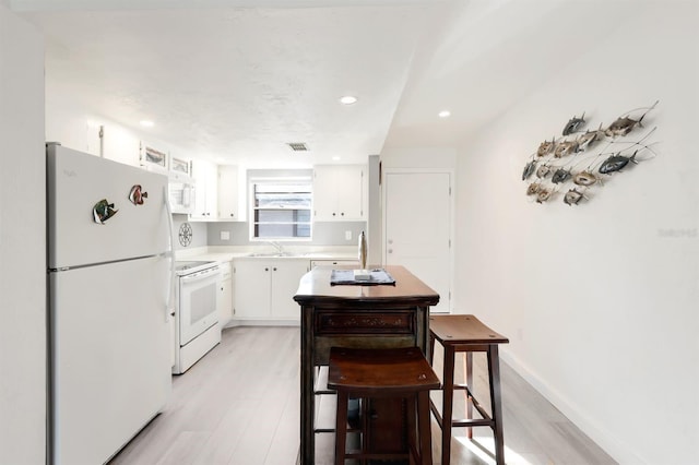 kitchen featuring white cabinets, light wood-type flooring, white appliances, and sink