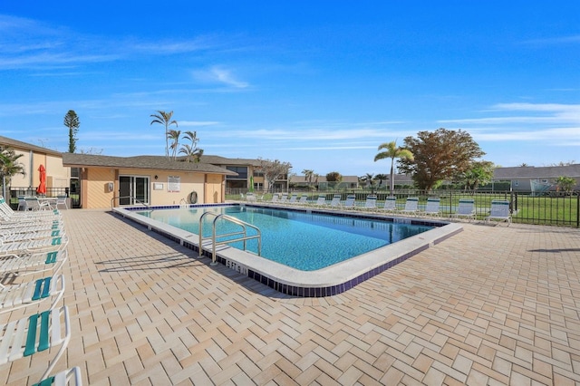 view of swimming pool featuring an outbuilding and a patio