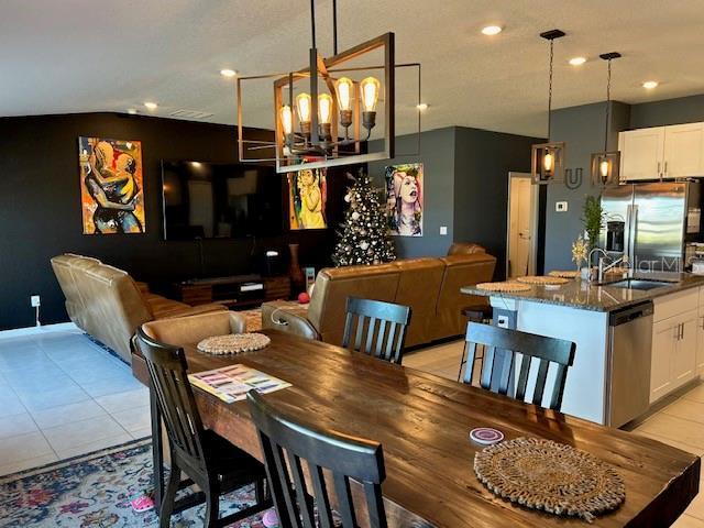 tiled dining room featuring sink and a chandelier