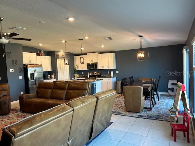 tiled living room featuring ceiling fan