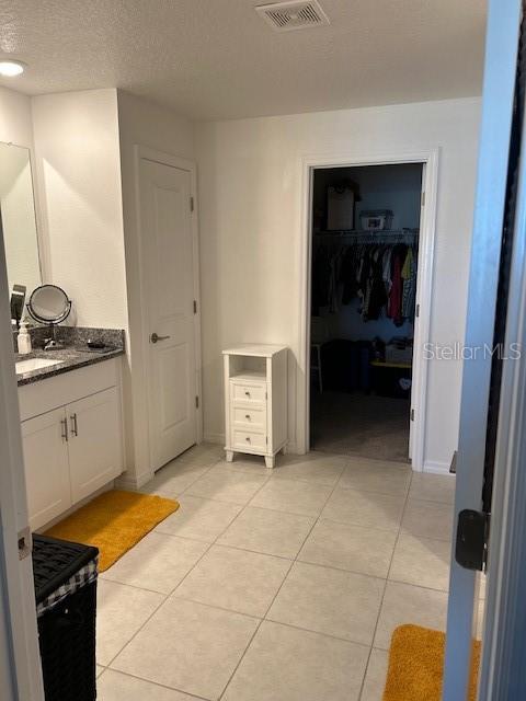 bathroom featuring tile patterned floors, vanity, and a textured ceiling