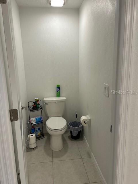 bathroom with toilet and tile patterned floors