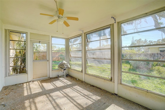 unfurnished sunroom featuring ceiling fan and a wealth of natural light