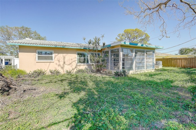 rear view of property with a sunroom and a yard