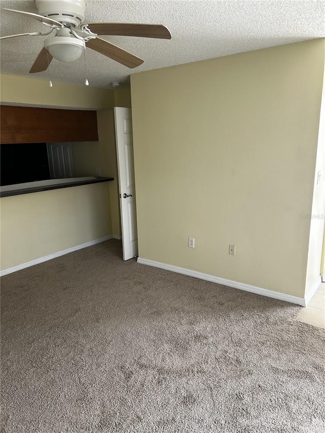 interior space with ceiling fan, carpet floors, and a textured ceiling