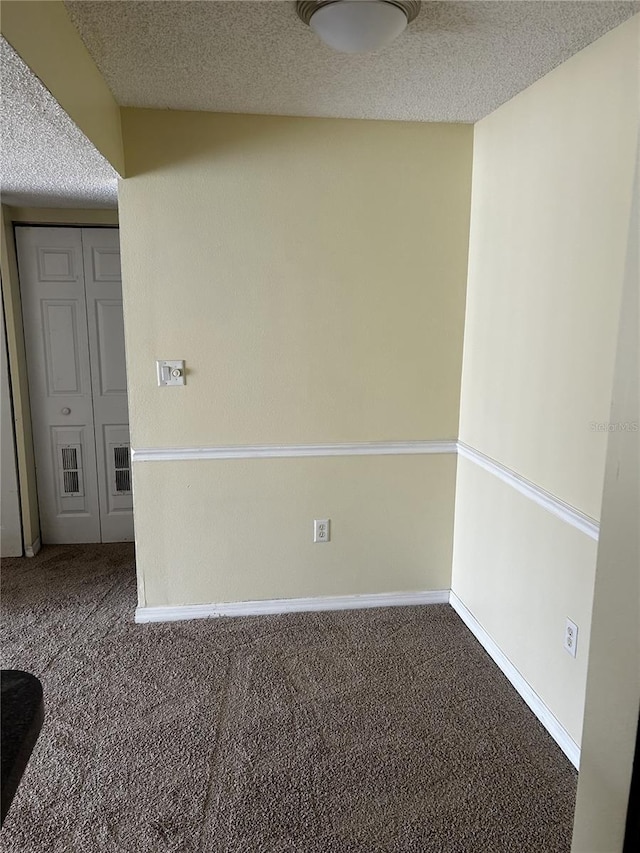 spare room featuring carpet floors and a textured ceiling