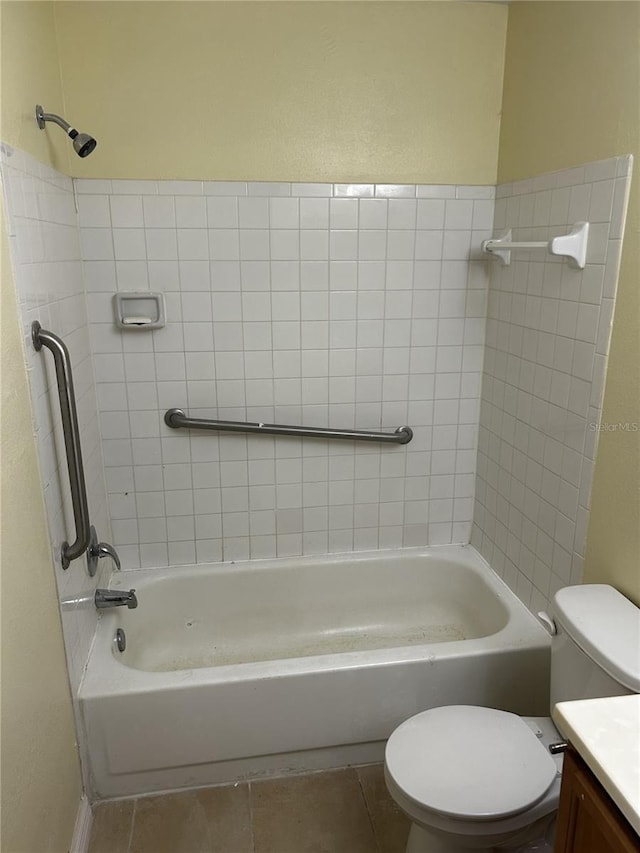 full bathroom with tile patterned flooring, vanity, tiled shower / bath combo, and toilet