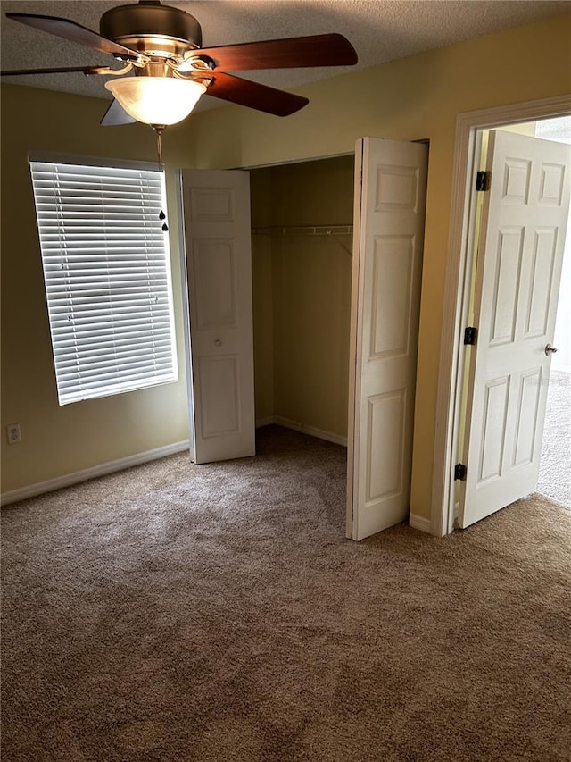 unfurnished bedroom featuring ceiling fan, carpet floors, a textured ceiling, and a closet