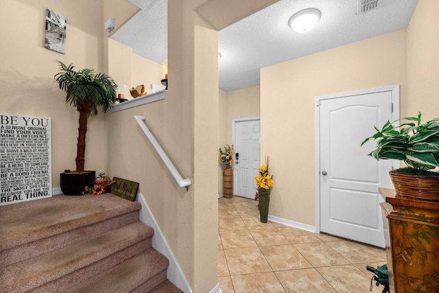 staircase featuring a textured ceiling and tile patterned floors