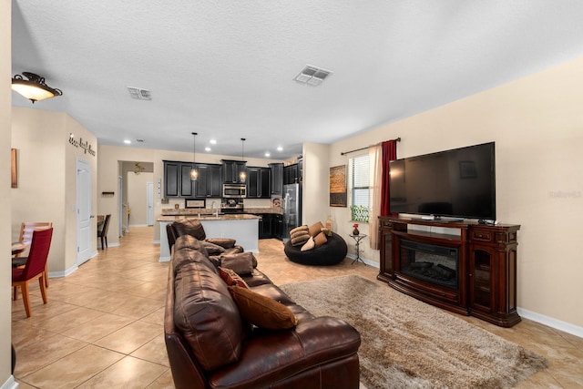 living room featuring light tile patterned floors and a textured ceiling