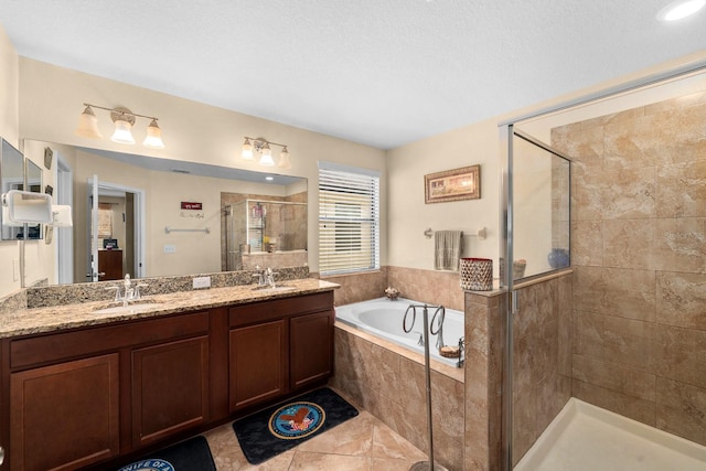 bathroom with tile patterned floors, vanity, plus walk in shower, and a textured ceiling