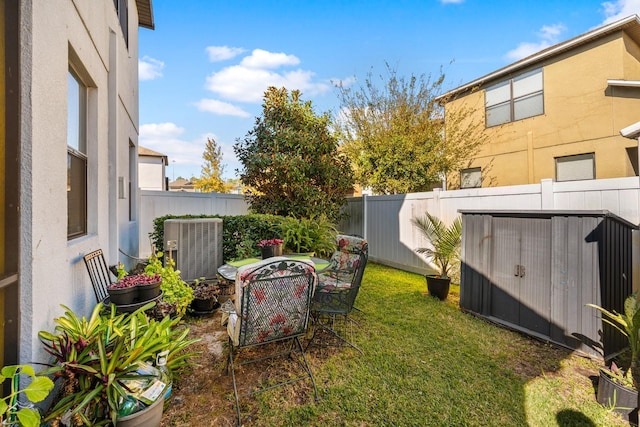 view of yard featuring a storage shed and central air condition unit