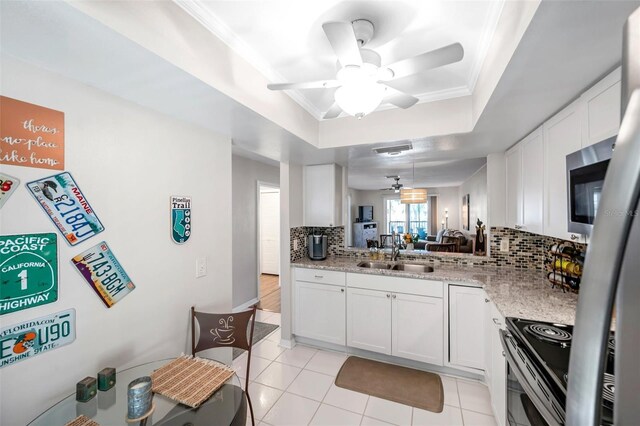 kitchen featuring white cabinets, backsplash, a raised ceiling, and sink