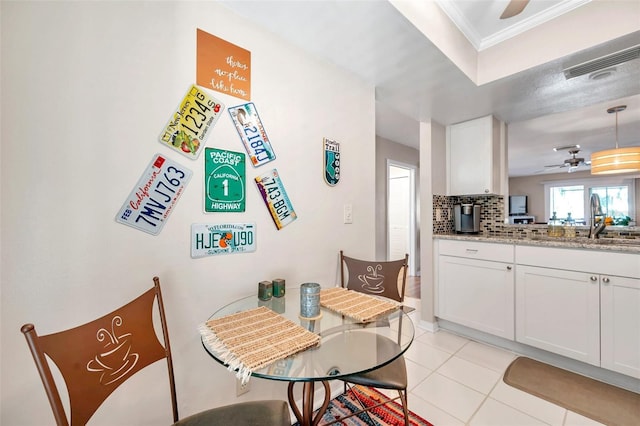 dining area with light tile patterned floors, ceiling fan, ornamental molding, and sink