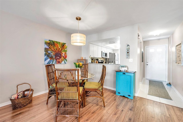 460 Paula Dr S Unit 101, Dunedin, FL 34698 - dining room featuring light wood-style flooring and baseboards