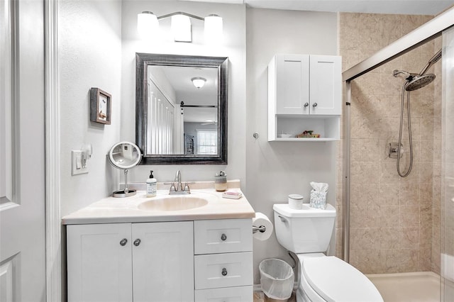 bathroom featuring vanity, toilet, and tiled shower