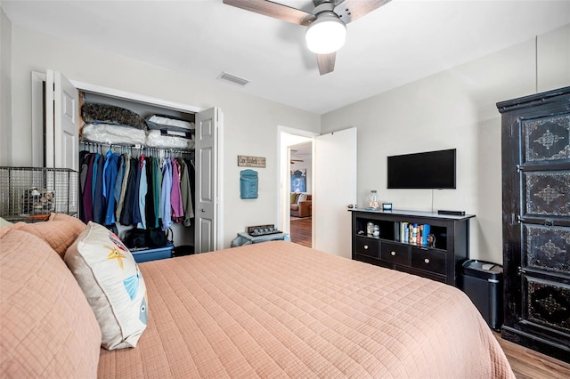 bedroom with hardwood / wood-style flooring, ceiling fan, and a closet